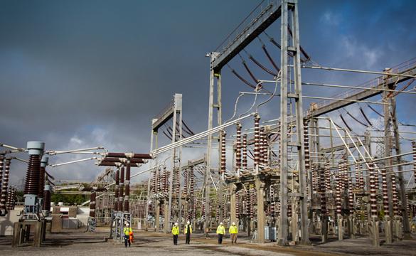 Engineers wearing PPE walking through an electricity substation