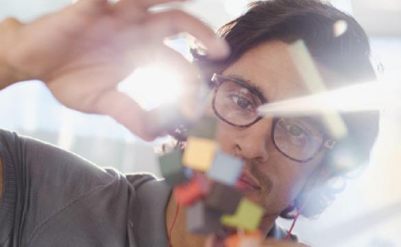 Man holding prototype of coloured cubes used for National Grid article about UK's economic recovery