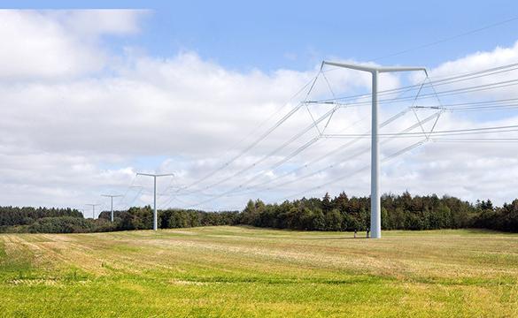 New electricity T-pylons and overhead lines running across a field with woods in the background