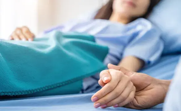 Holding hands with hospital patient for National Grid story 'Supporting carers during stressful times'