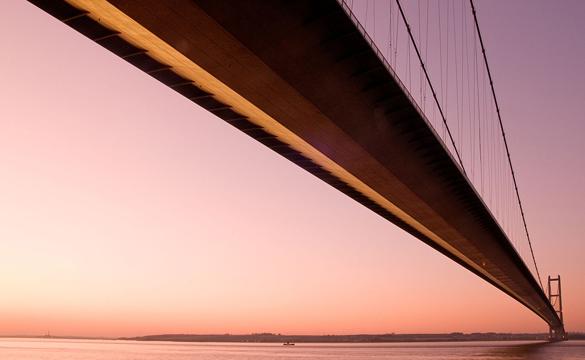 The Humber Bridge seen from below against a pink sky