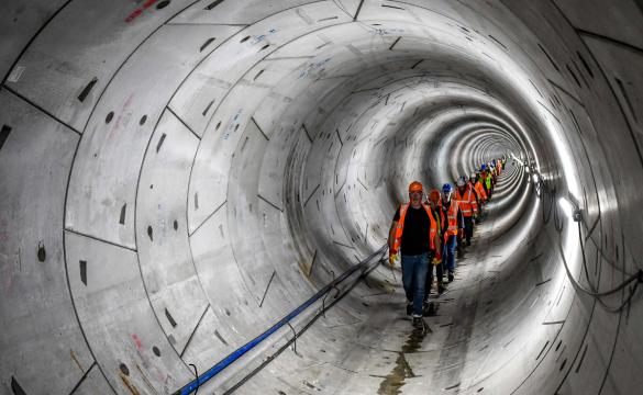 A line of people wearing hard hats and high-vis walking through the Humber Tunnel - used for the National Grid story 'Celebrating the completion of the Humber Tunnel'