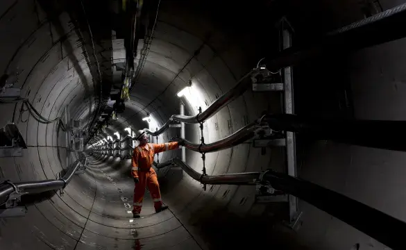 National Grid engineer inspecting the inside of a metallic tunnel structure 