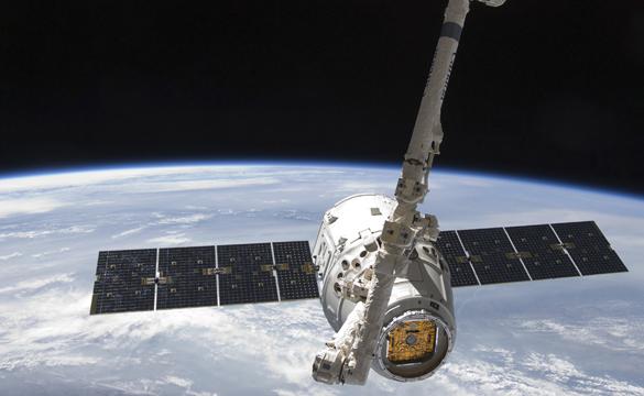 Space X Dragon satellite orbiting earth