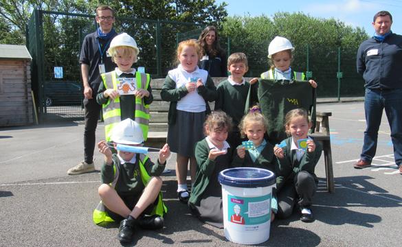 Group of school children preparing a time-capsule to put inside a T-pylon
