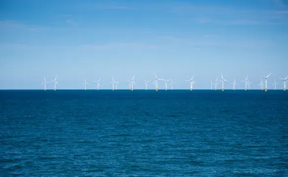Wind farm in the distance at sea for National Grid 'Green loan speeds race to net zero' story