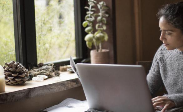 Woman working on a laptop in front of a window - used for the National Grid story 'Looking after our people in uncertain times'