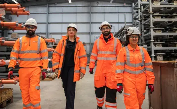 National Grid colleagues wearing PPE walking together in a warehouse