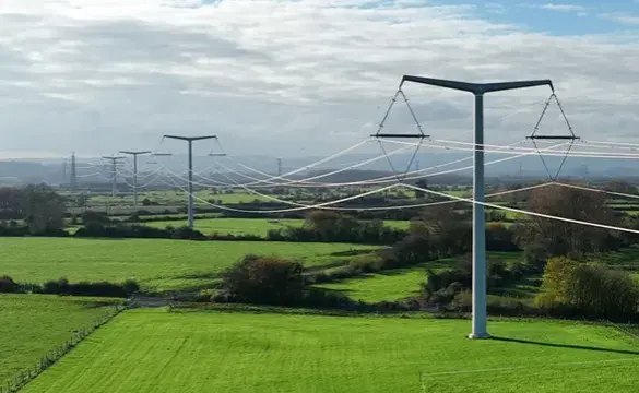 T-pylons and overhead electricity lines across green fields