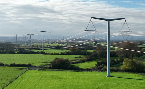T-pylons and overhead electricity lines across green fields
