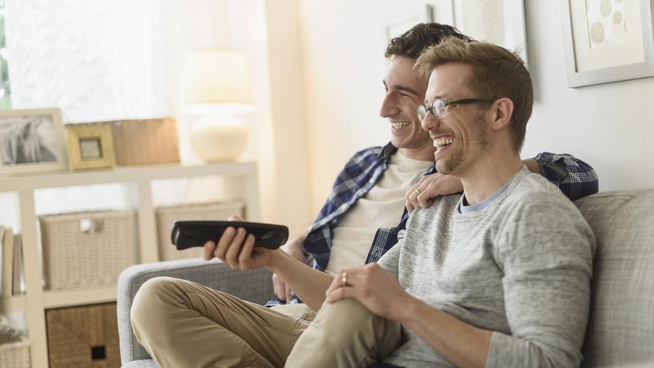 Couple sitting on a sofa watching TV