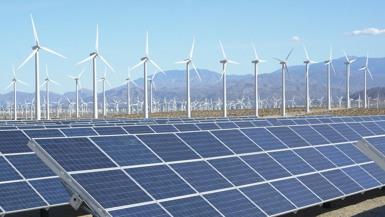 Solar and wind farm with mountains in the background