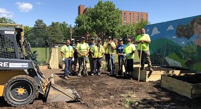 Crew members digging in garden