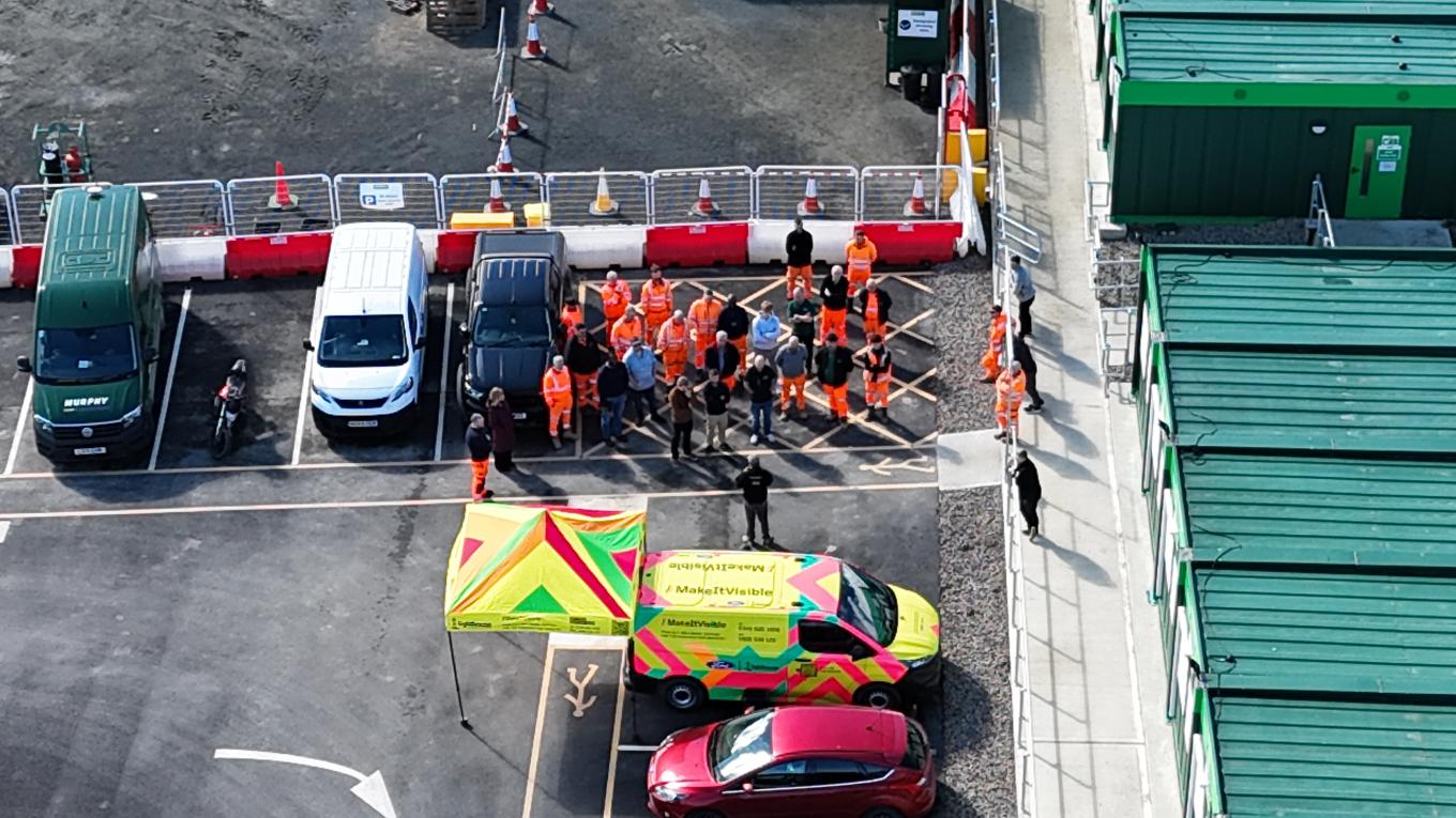 Drone Image of People in Construction Gear Near Vans