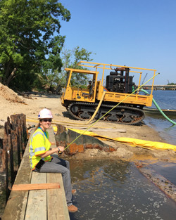 Female National Grid US engineer Cindy Rom wearing PPE by river