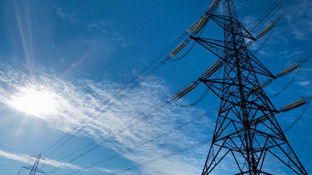 Lattice electricity pylons and overhead lines against a blue sky