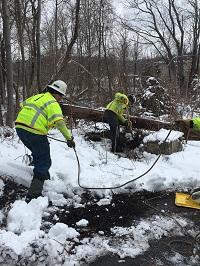 Two National Grid lineworkers digging in the snow in the US