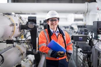 Suzanne Bryant holding a file in a workshop environment.