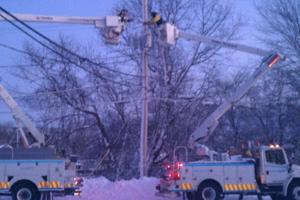 US lineworkers repairing lines from National Grid buckete trucks in snow storm