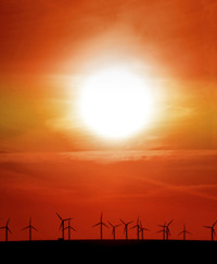 Wind turbines in the distance beneath a red sky with a bright sun - used for the National Grid story 'Sky’s COBRA series – a (solar) storm in a teacup or genuine possibility?'