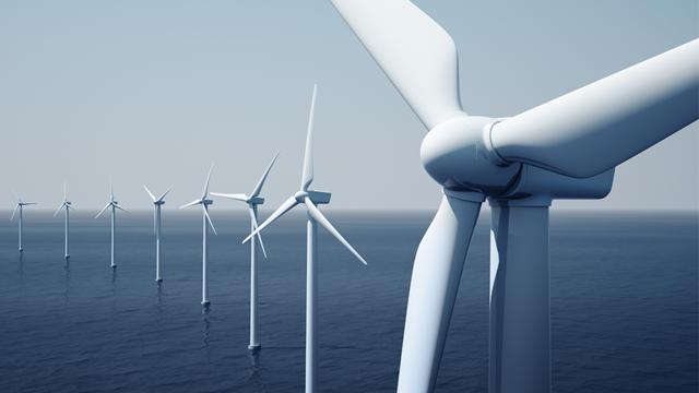 Row of white wind turbine blades in the sea at an offshore wind farm