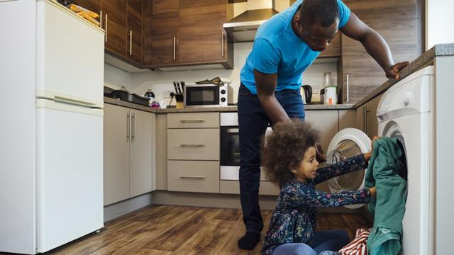 Parent and child loading the washing machine