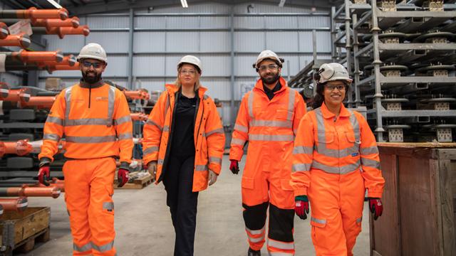 National Grid colleagues wearing PPE walking together in a warehouse