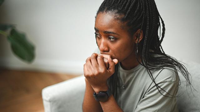 Sad young woman sitting on a sofa