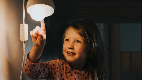 girl looks at lightbulb in wonder