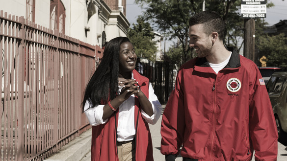 Two young people smiling and walking down an American sidewalk 