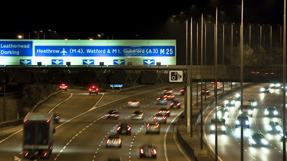 Cars driving along the M25 motorway in England at night