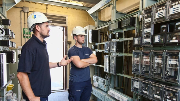 Two National Grid workers assessing the internal parts of an electricity system