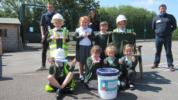 Group of school children preparing a time-capsule to put inside a T-pylon