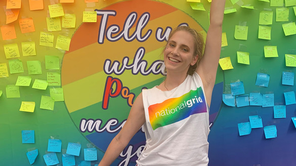 National Grid Pride colleague in front of colourful board with posters