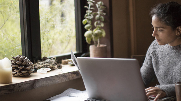 Woman working on a laptop in front of a window - used for the National Grid story 'Looking after our people in uncertain times'