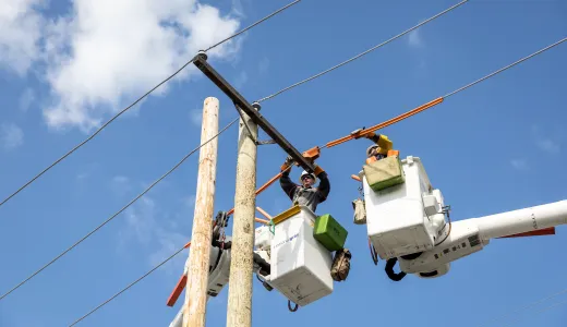 Lineworkers on overhead power lines