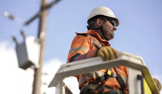Man in PPE attending to overhead lines 