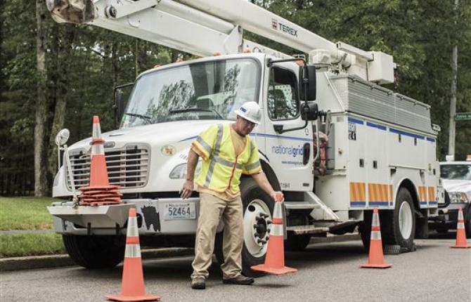 A National Grid worker setting out traffic cones alongside a truck 