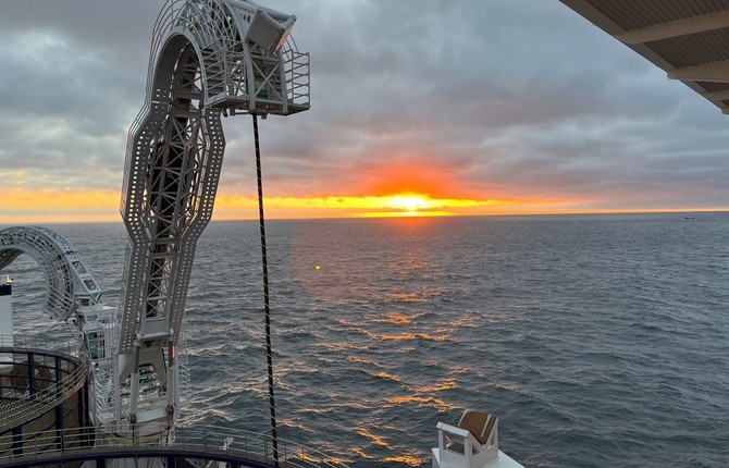 Cable being installed from a cable laying vessel at sunset