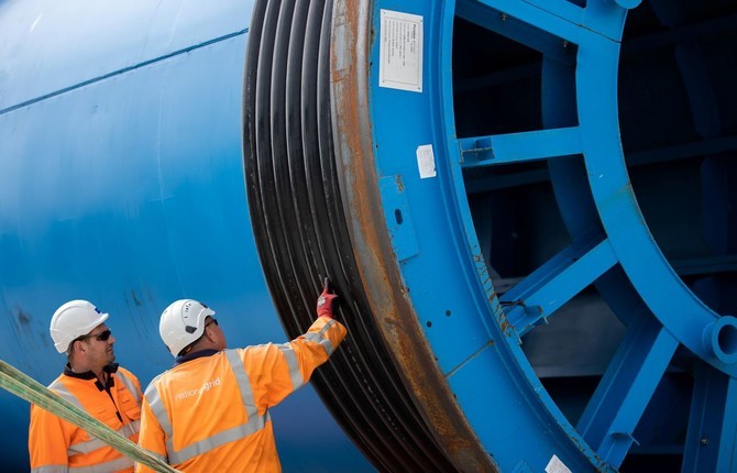 Engineers wearing PPE standing next to a Viking Link land cable drum
