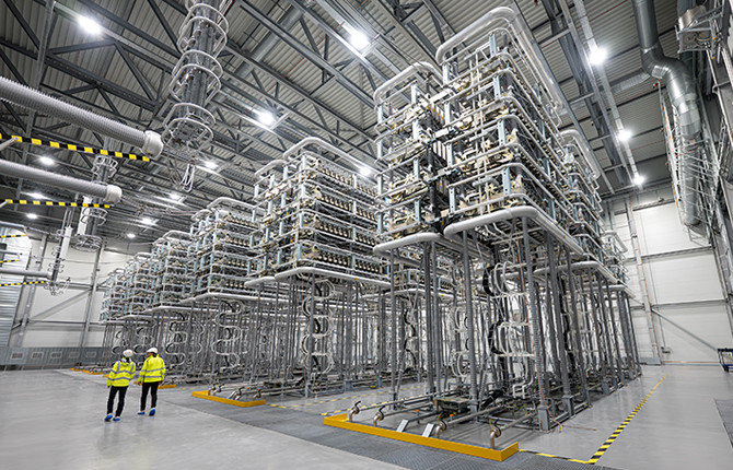 Two people wearing hi-vis jackets and PPE in the Viking Link valve hall