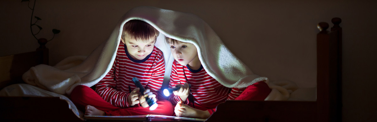 Children reading by torchlight