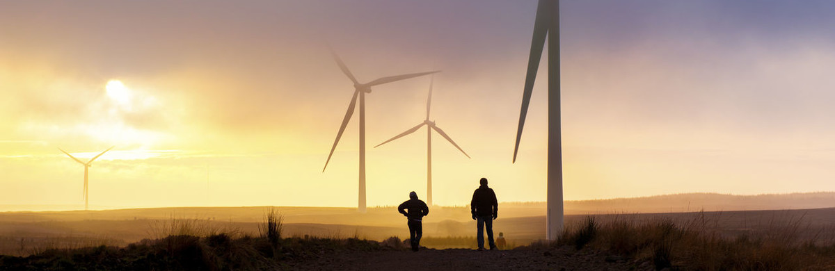 People walking across fields next to wind turbines - used for the National Grid story '200MW Crocker Wind Farm brings cleaner power online'