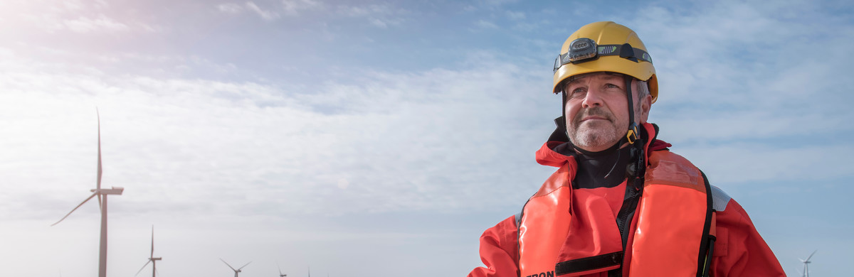Engineer wearing PPE and lifejacket on a boat at an offshore windfarm