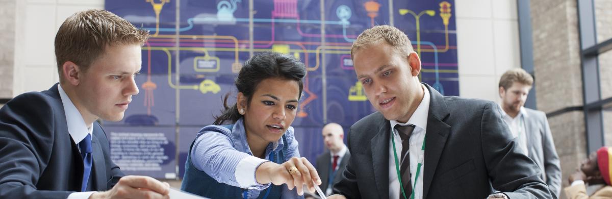 Three National Grid employees looking at paperwork with an office setting in the background