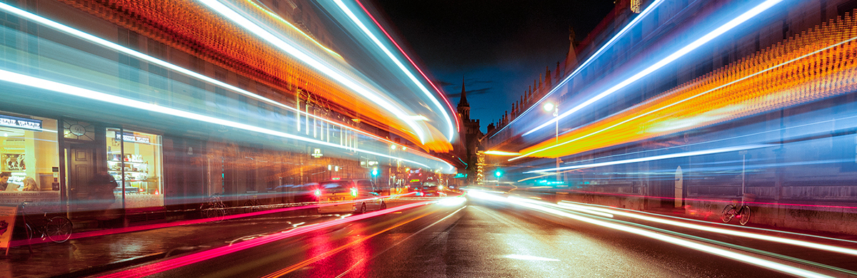A busy city road at night with blurred lights moving through the image