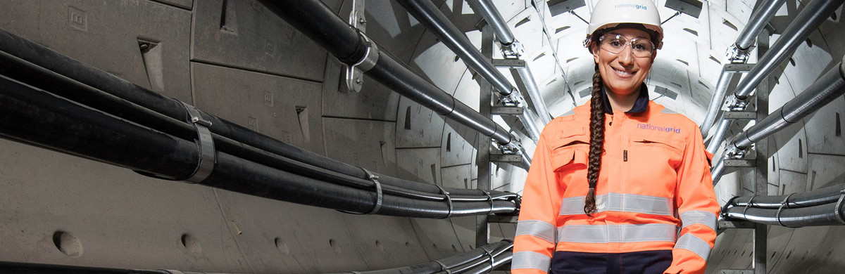 Female engineer wearing hard hat, safety goggles and overall inside London Power Tunnel - used for the National Grid story '400,000 new energy workers needed to power UK to net zero'