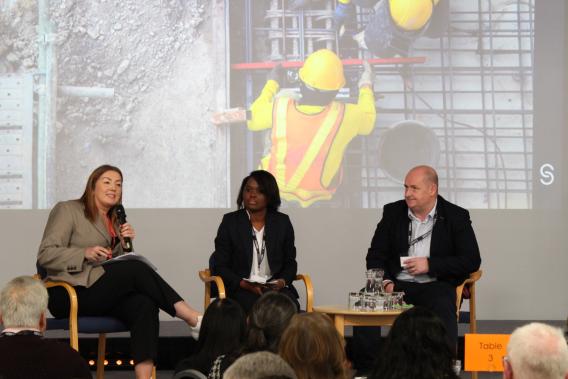 Three people speaking at a conference