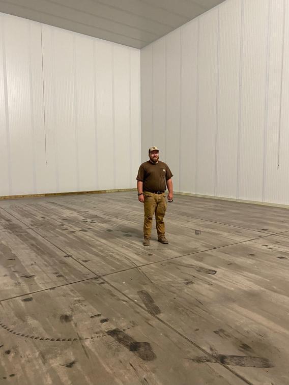 Max Russell stands in one of Russell Farms