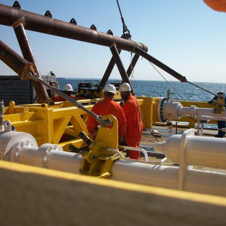 National Grid employees working on a gas rig with the ocean in the background 